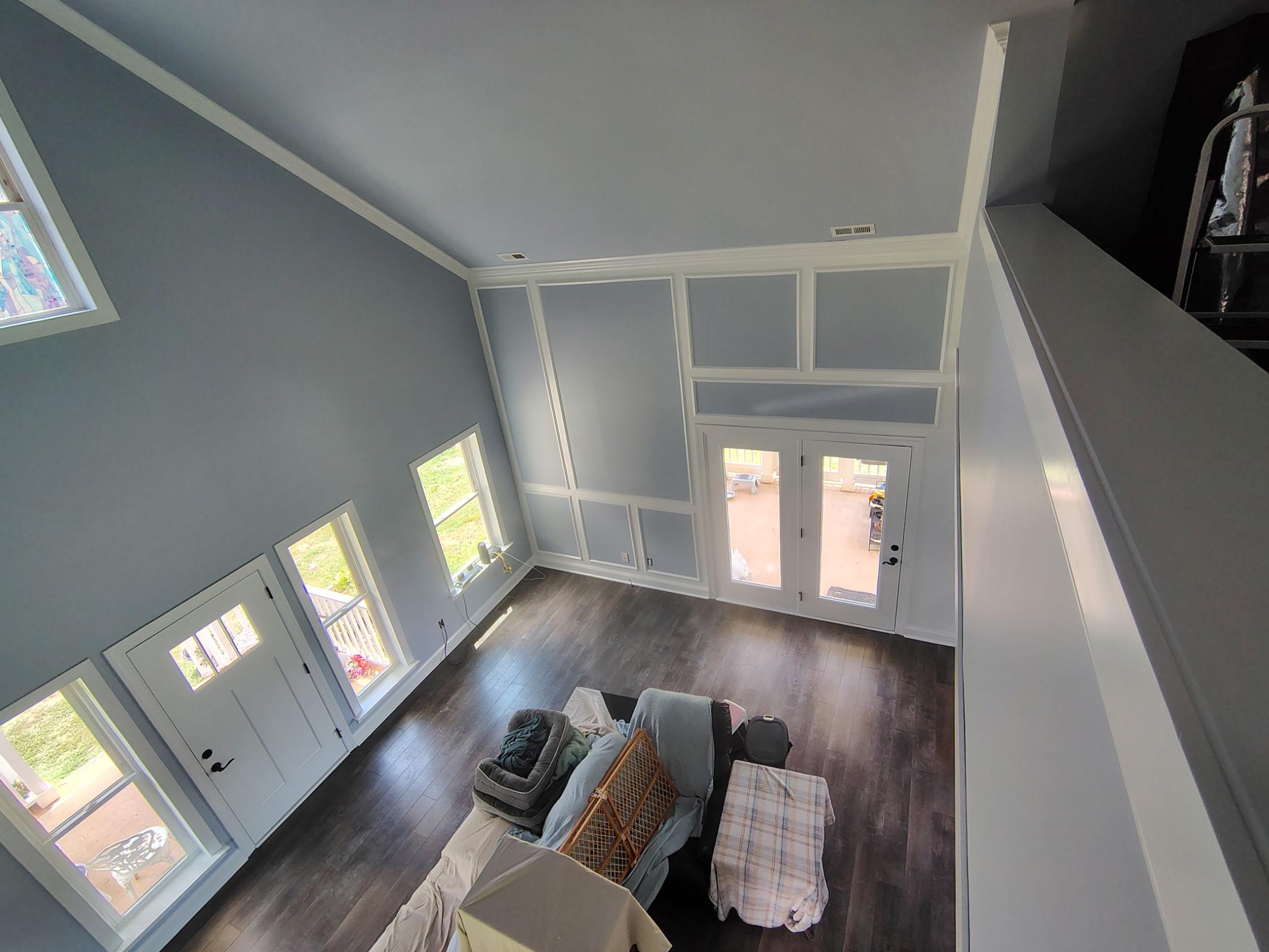 Interior painting in Burlington, NC — freshly painted living room with blue-gray walls and white wainscoting trim